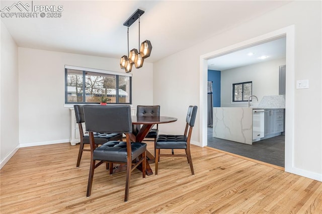 dining area with an inviting chandelier and light hardwood / wood-style flooring