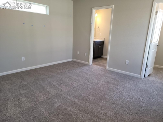 unfurnished bedroom with connected bathroom and carpet