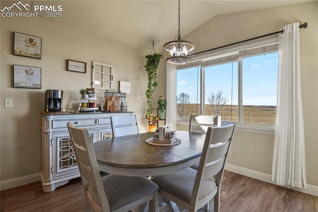 dining space with lofted ceiling, a notable chandelier, and hardwood / wood-style floors