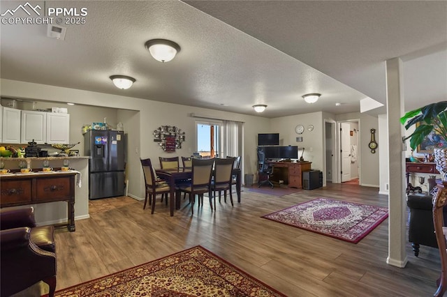 dining room featuring hardwood / wood-style flooring and a textured ceiling