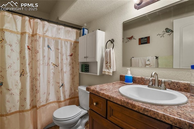 bathroom featuring a textured ceiling, toilet, vanity, and a shower with curtain