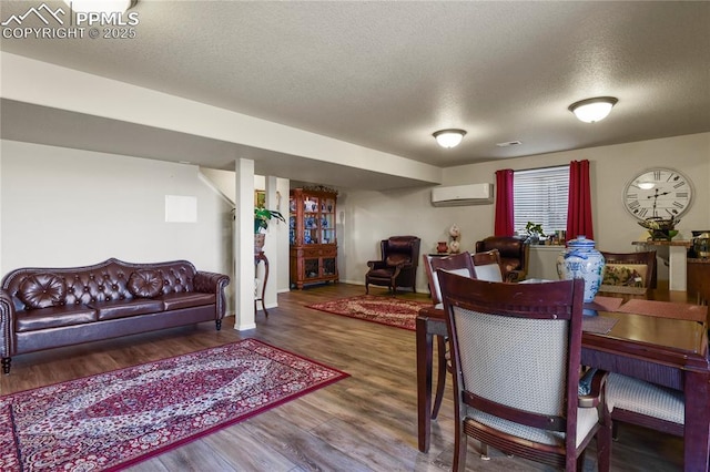 dining space featuring hardwood / wood-style floors, a textured ceiling, and a wall mounted air conditioner