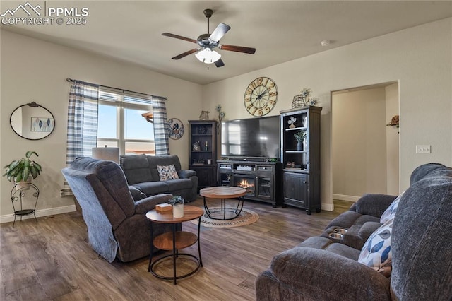 living room featuring ceiling fan and dark hardwood / wood-style floors