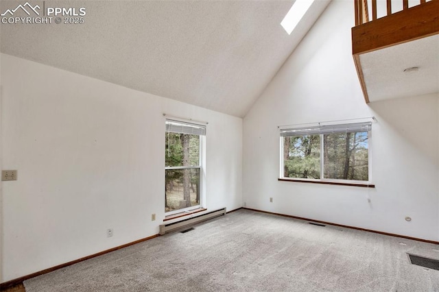 interior space with a skylight, carpet flooring, high vaulted ceiling, and a baseboard radiator