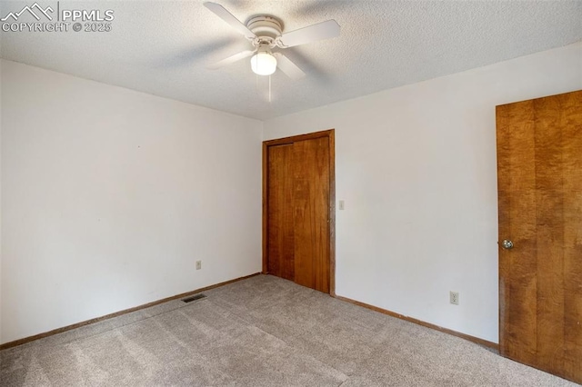 carpeted empty room with a textured ceiling and ceiling fan