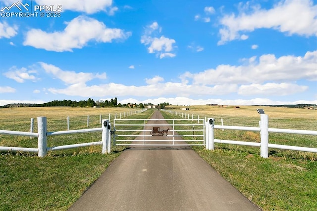 view of gate featuring a rural view and a yard