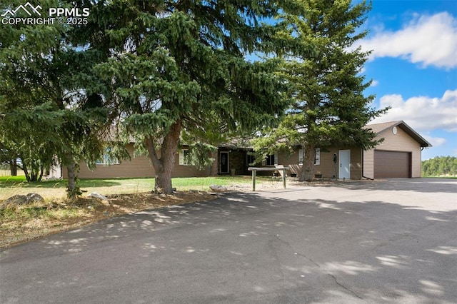 view of property hidden behind natural elements featuring a garage