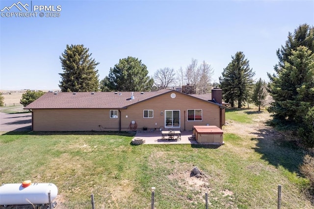 back of property featuring a patio area, a jacuzzi, and a yard