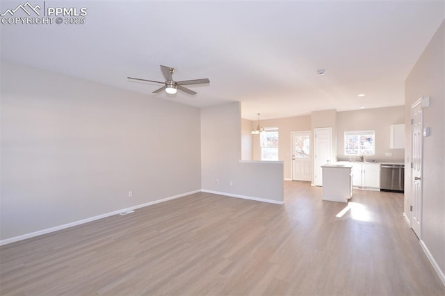 unfurnished living room with light hardwood / wood-style floors and ceiling fan with notable chandelier