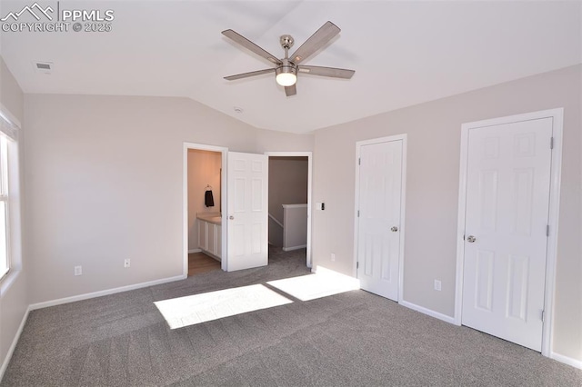 unfurnished bedroom featuring ceiling fan, multiple closets, connected bathroom, and dark colored carpet