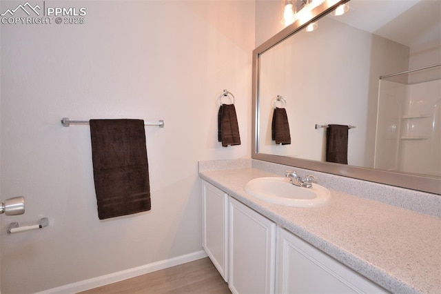 bathroom featuring vanity, wood-type flooring, and a shower