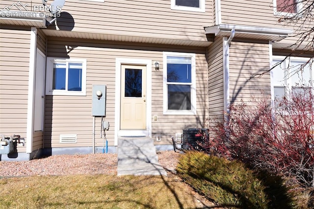 view of exterior entry with a yard