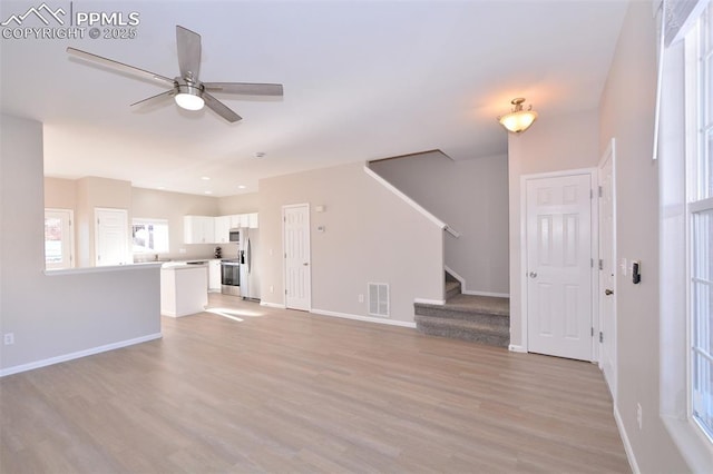 unfurnished living room featuring ceiling fan and light hardwood / wood-style flooring