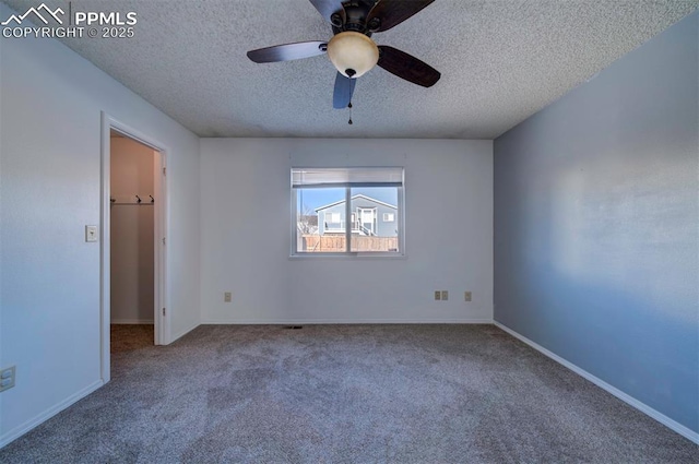 spare room featuring a textured ceiling, ceiling fan, and carpet