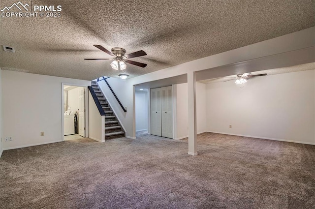 basement with a textured ceiling, ceiling fan, carpet flooring, and washer / clothes dryer