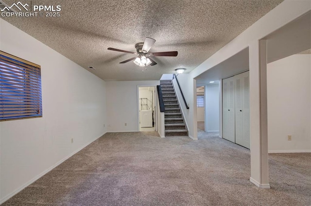 interior space with light carpet, ceiling fan, and a textured ceiling