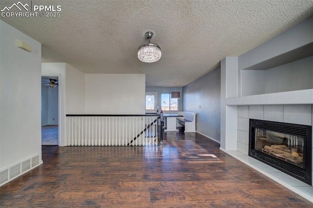 corridor featuring built in shelves, dark hardwood / wood-style floors, and a textured ceiling