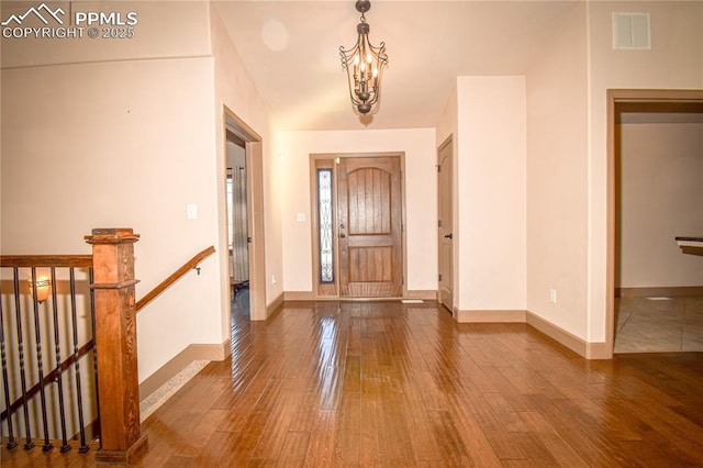 entryway with hardwood / wood-style floors and an inviting chandelier