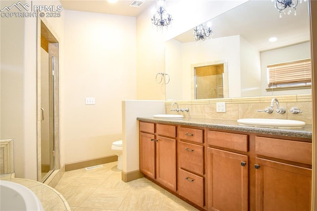 bathroom with tile patterned flooring, toilet, walk in shower, vanity, and decorative backsplash