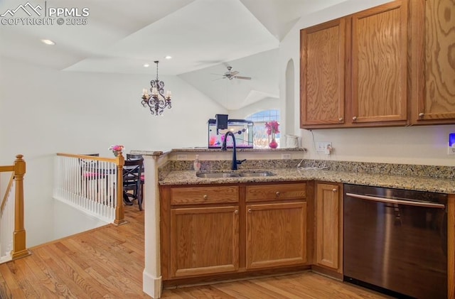 kitchen featuring stainless steel dishwasher, vaulted ceiling, sink, light wood-type flooring, and light stone counters