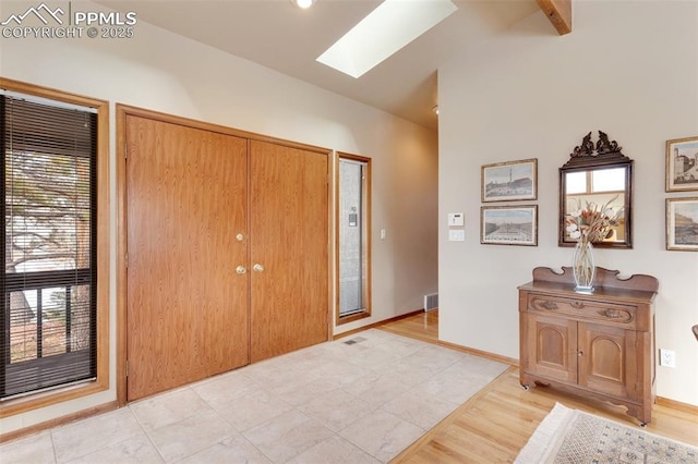 foyer featuring lofted ceiling with skylight