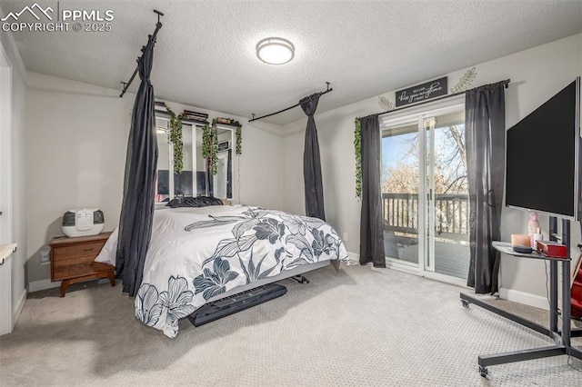 bedroom with access to exterior, carpet, and a textured ceiling