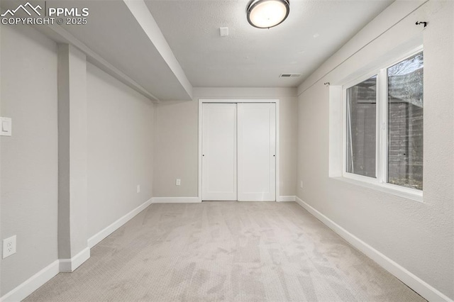 unfurnished bedroom with a closet and light carpet