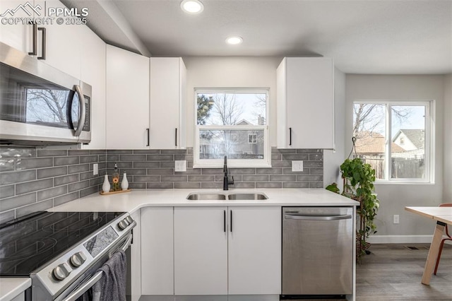 kitchen with sink, white cabinets, and appliances with stainless steel finishes