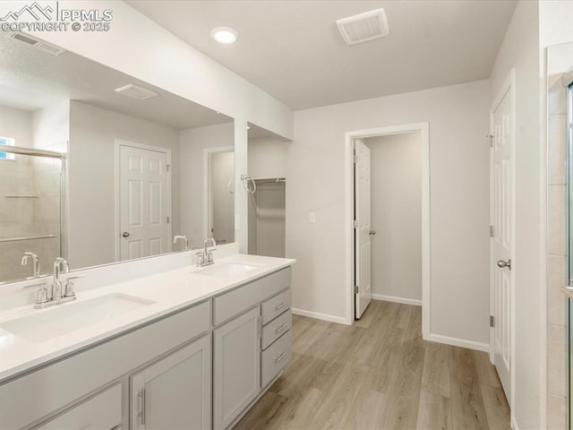 bathroom featuring an enclosed shower, vanity, and hardwood / wood-style flooring