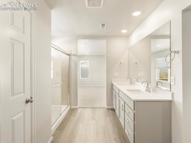 bathroom with an enclosed shower, vanity, and hardwood / wood-style floors