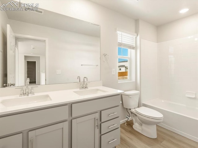 full bathroom with toilet, vanity, shower / bathtub combination, and hardwood / wood-style flooring