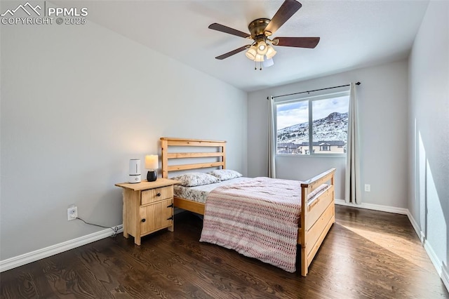 bedroom featuring ceiling fan, dark hardwood / wood-style floors, and a mountain view