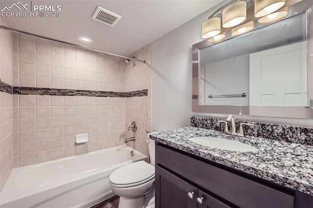 full bathroom with toilet, vanity, and tiled shower / bath