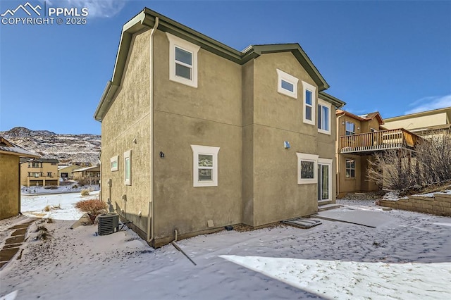 snow covered property with a mountain view and a balcony