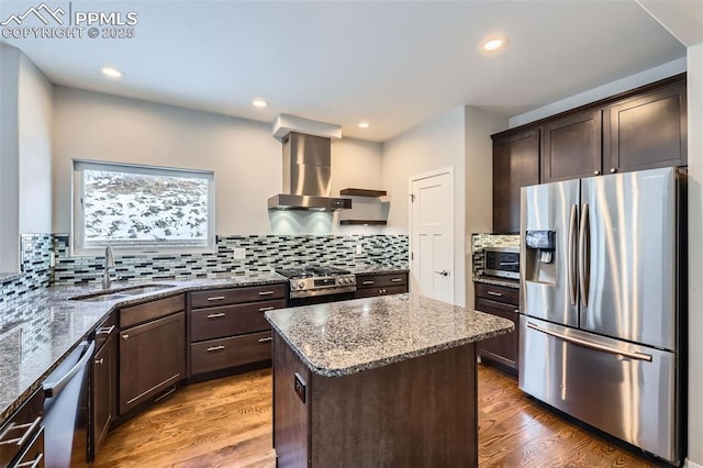 kitchen featuring sink, island exhaust hood, hardwood / wood-style floors, a center island, and stainless steel appliances