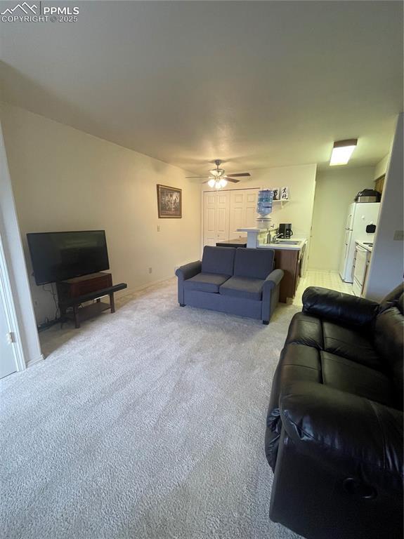 carpeted living room featuring ceiling fan