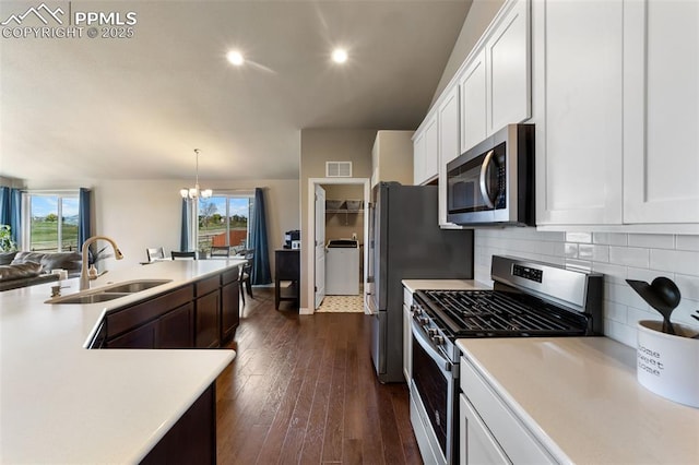 kitchen featuring white cabinets, decorative light fixtures, stainless steel appliances, sink, and a chandelier