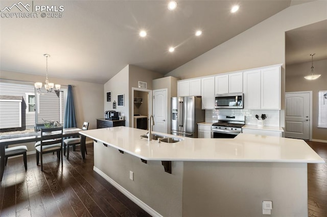 kitchen featuring stainless steel appliances, tasteful backsplash, a spacious island, hanging light fixtures, and sink