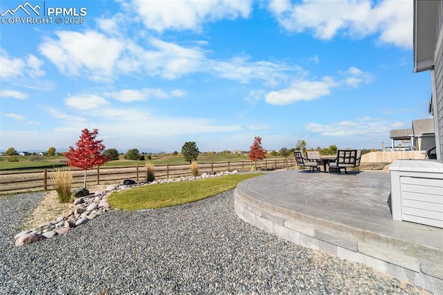 view of yard with a rural view and a patio area