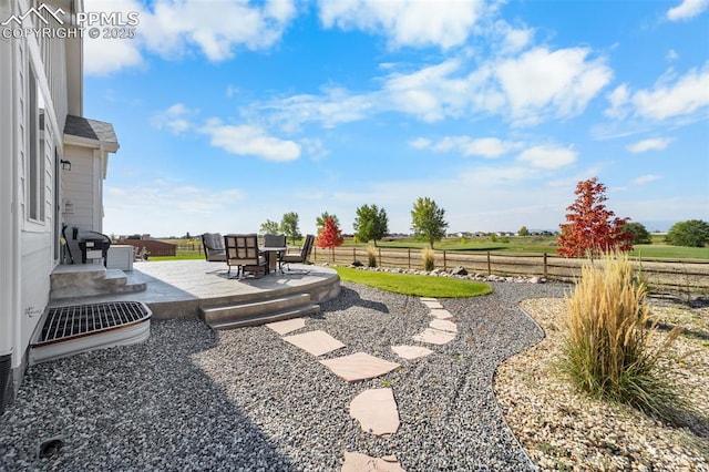 view of yard with a rural view and a patio area