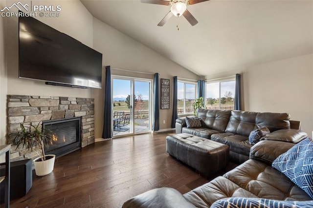 living room featuring ceiling fan, dark hardwood / wood-style floors, a stone fireplace, and high vaulted ceiling