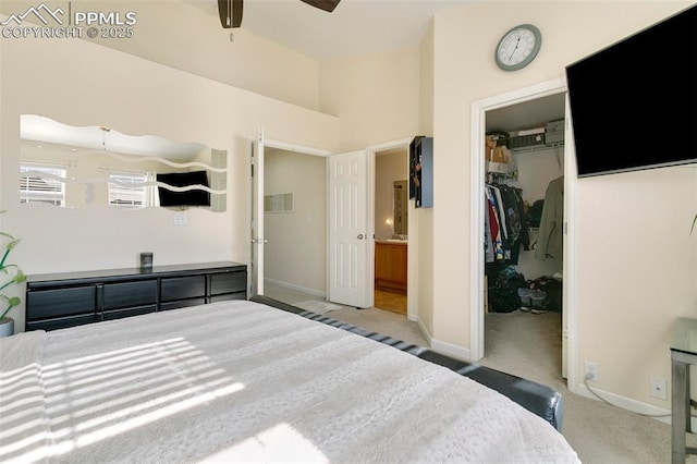 bedroom with a walk in closet, ensuite bathroom, carpet floors, and a closet