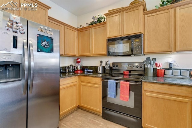 kitchen with light wood-type flooring, black appliances, dark stone counters, and light brown cabinets