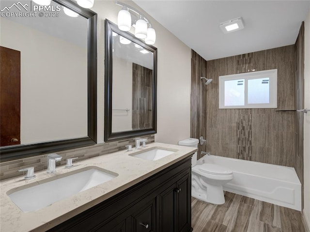 full bathroom with tasteful backsplash, tiled shower / bath combo, vanity, and toilet