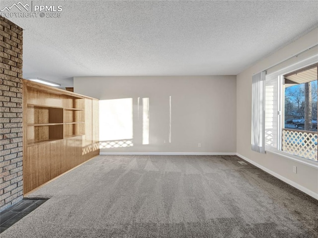 carpeted spare room with a fireplace and a textured ceiling