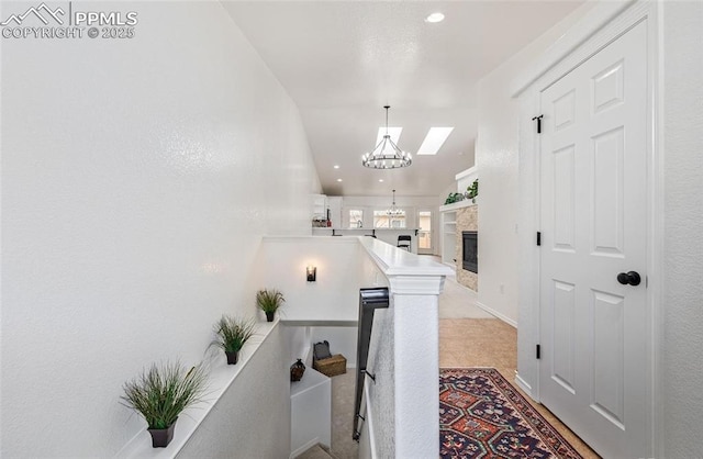 hallway featuring built in shelves and a notable chandelier