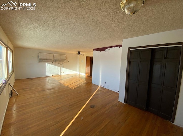 interior space featuring a textured ceiling, ceiling fan, and wood-type flooring