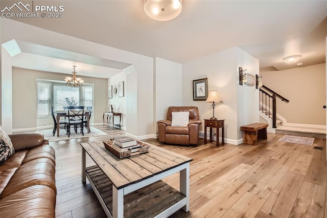 living room with an inviting chandelier and hardwood / wood-style flooring