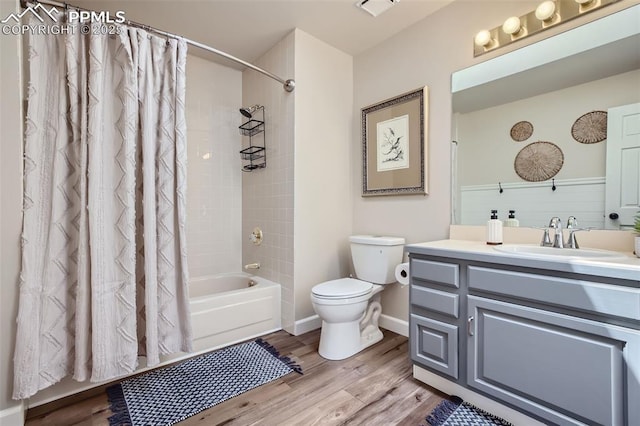 full bathroom featuring shower / bath combo with shower curtain, hardwood / wood-style floors, toilet, and vanity