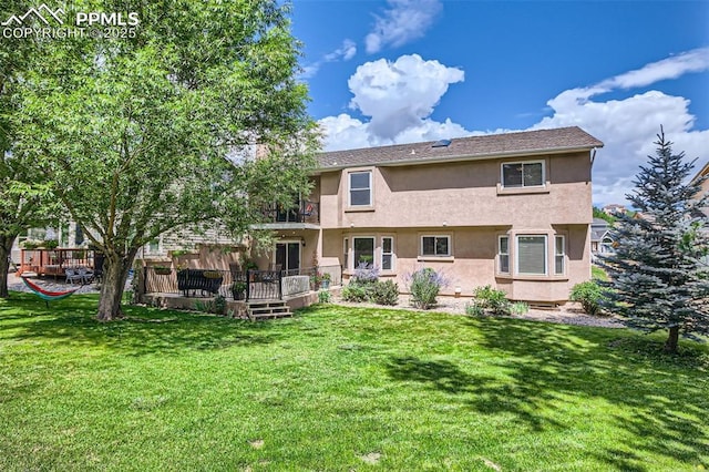 rear view of property with a wooden deck and a yard